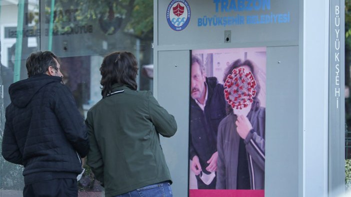 Trabzon'da durakta maske takmayanları dijital ekran uyarıyor