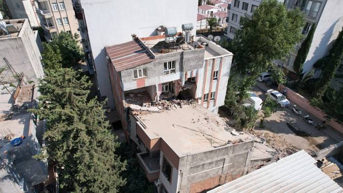 Depremde hasar alan bina yıkım esnasında yandaki binanın üzerine yıkıldı